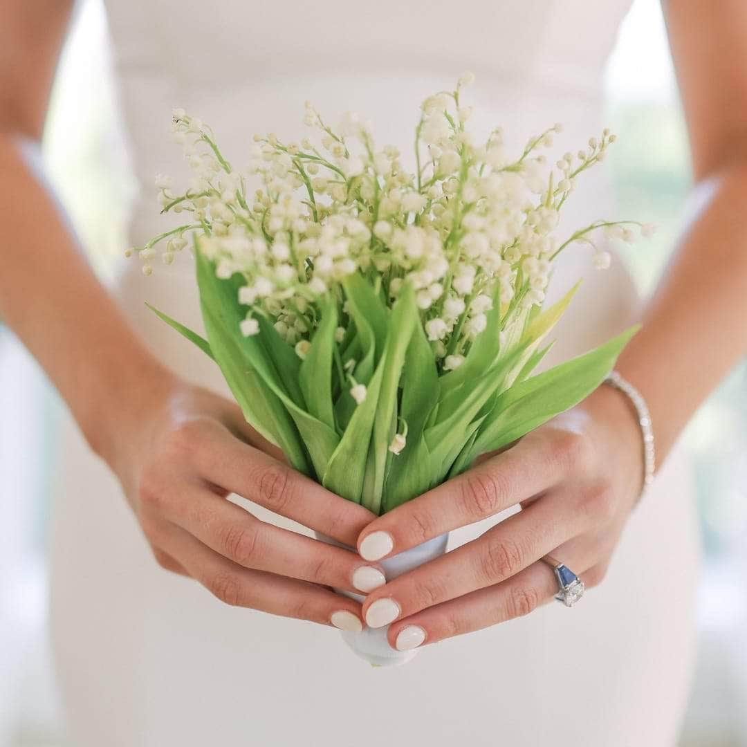 Bride holding Lily of the Valley bouquet - dbandrea
