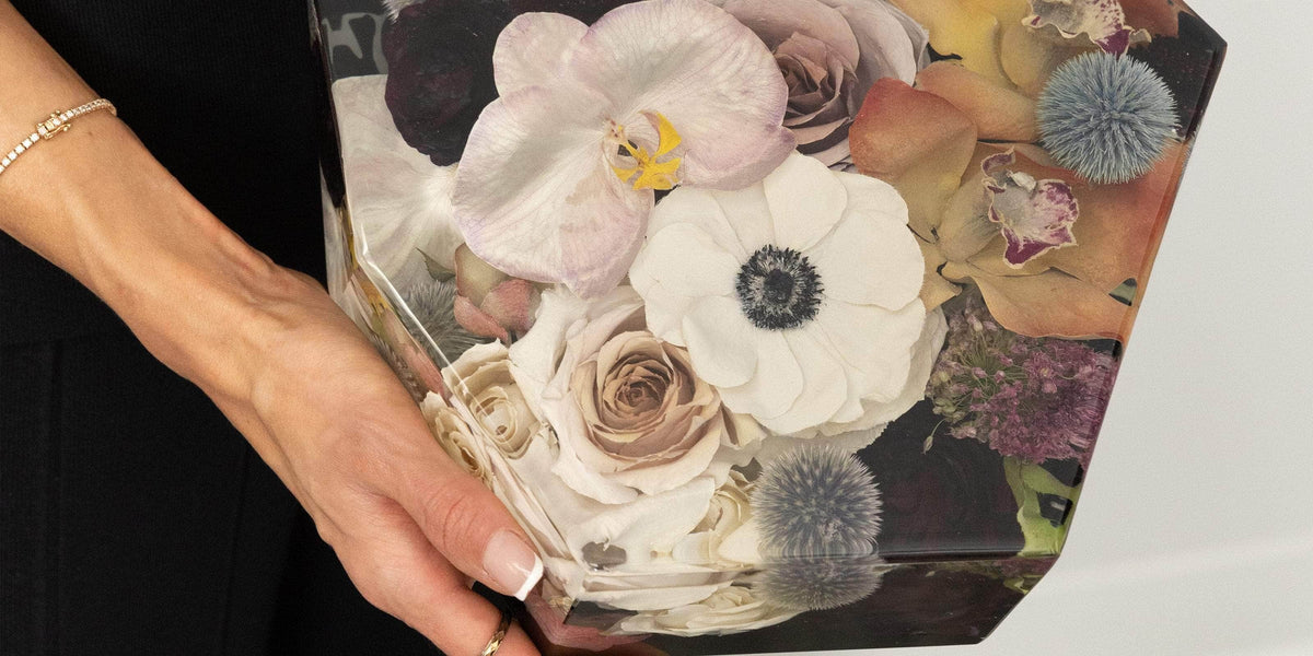 Woman holding preserved flowers in resin block - dbandrea
